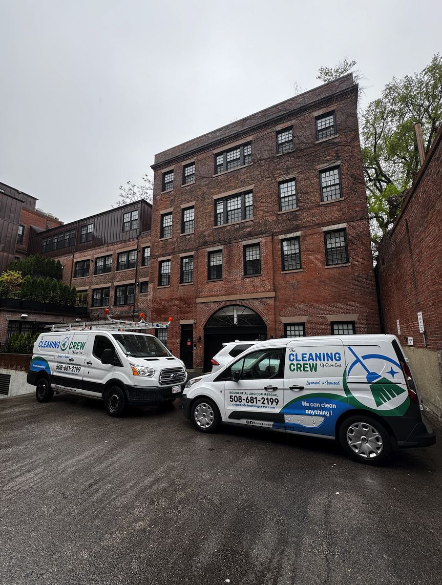 Two crew vans outside a brick city building